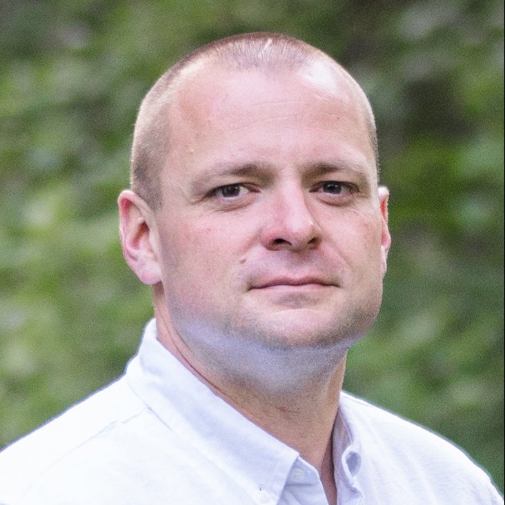 Headshot of Caucasian male in white shirt outside - Darren Aiello, Assistant Professor of Finance
