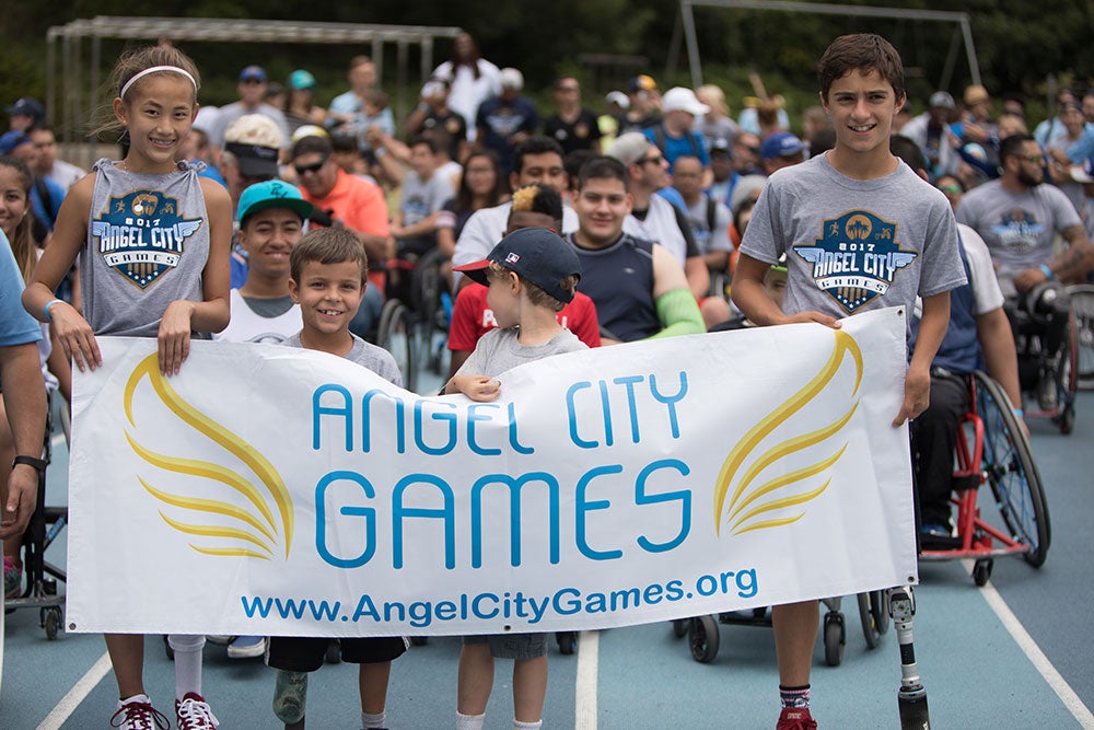Young adults holding a sign - Angel City Games