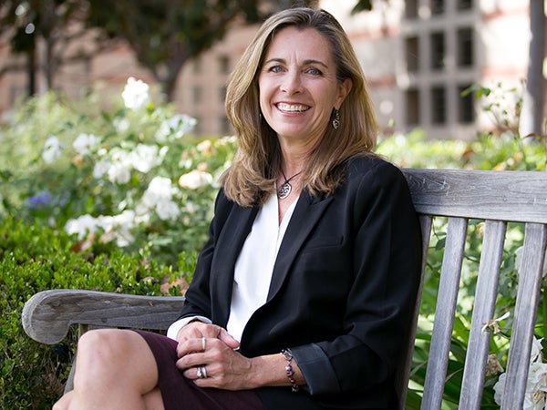 Gayle Northrop sitting on a bench at UCLA Anderson complex