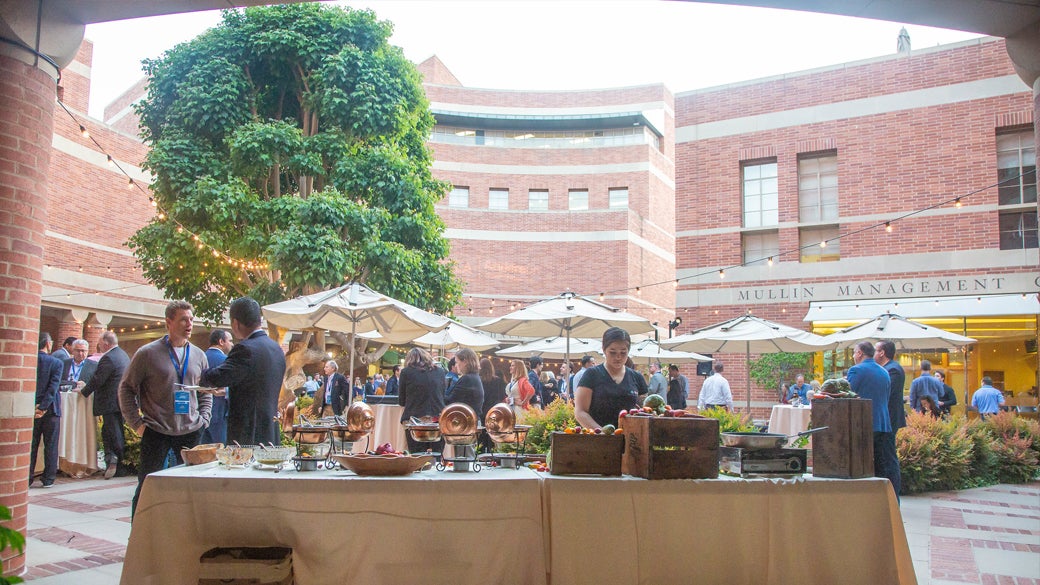 People at an event hosted at Marion Anderson Courtyard with view of a buffet table