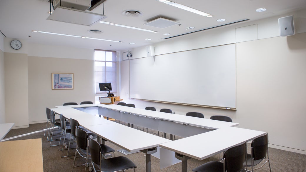 Empty flat classroom space at UCLA Anderson with whiteboard and projector access