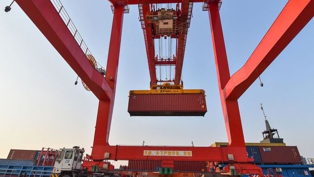 Underneath a crane moving a container at a sea port