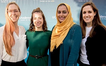 Four women in front of an Anderson step and repeat backdrop