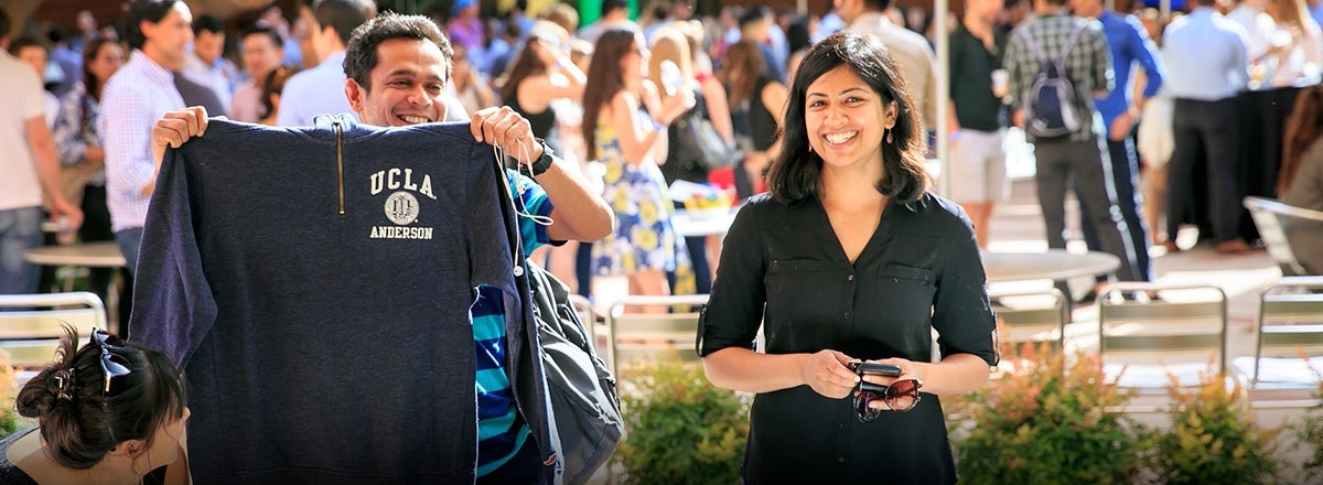 Student holding up a UCLA Anderson sweater